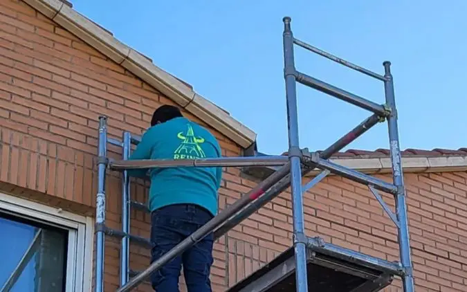 Trabajador de Reinza arreglando junta de fachada