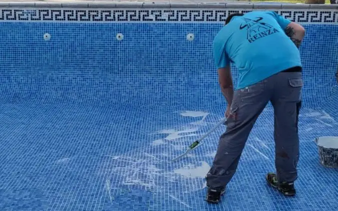 Trabajador de Reinza arreglando piscina